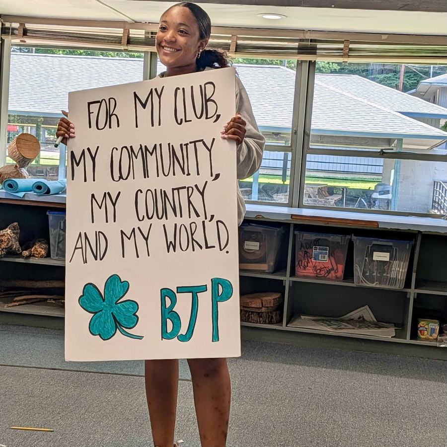 Girl holding sign with 4-H pledge