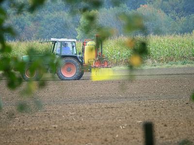 Tractor spraying pesticide on field