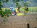Tractor spraying pesticide on field