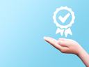 Hand supporting a checkmark symbolizing meeting a requirement.