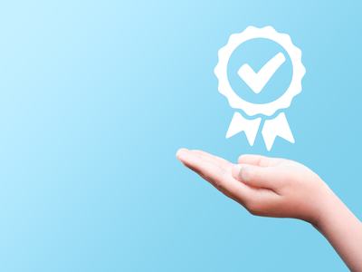 Hand supporting a checkmark symbolizing meeting a requirement.