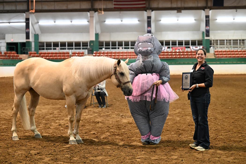 Alumni Showmanship Sponsorship Challenge winner, Samantha Taylor, posing with her palomino horse and Alaina Cross. Samantha is where a hippopotamus costume.