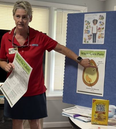 Angie standing in front of display board with whole grain image