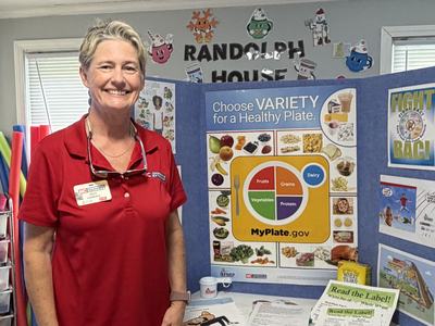 Angie standing in front of display board with myplate image
