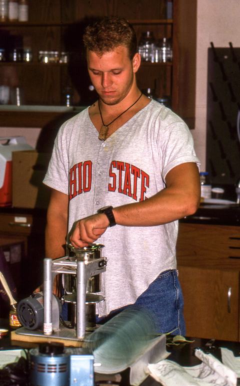Person using mite-brushing machine in lab