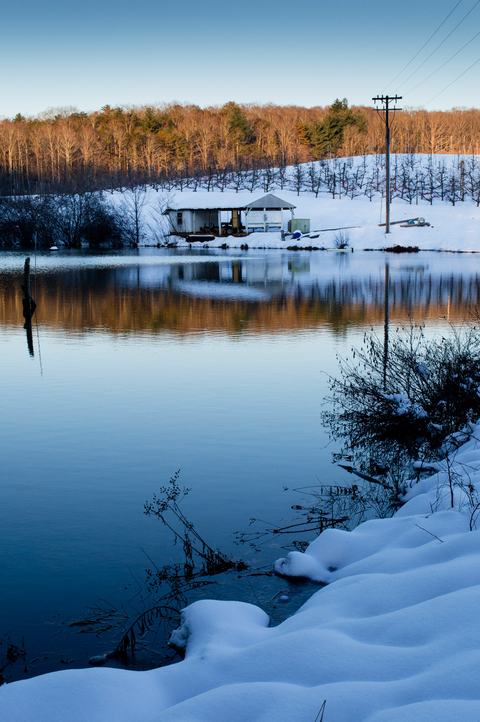 Orchard pond with snow and irrigation pump house