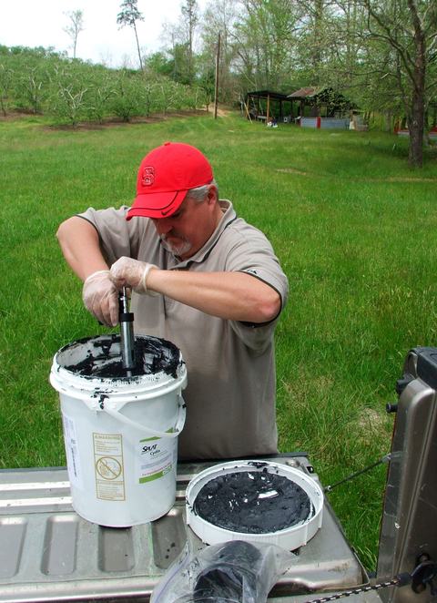Person working with gooey material in bucket