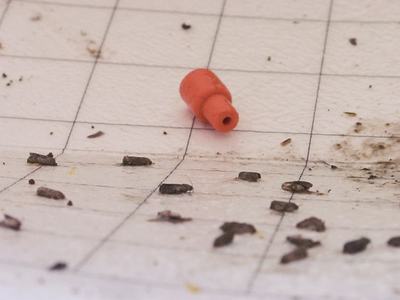 Moths stuck on white sticky card with rubber synthetic pheromone dispenser.