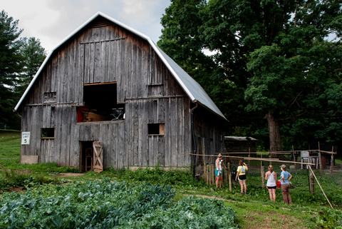 People with barn and crop field