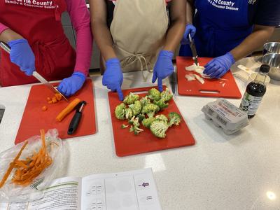 Students chopping vegetables on a cutting board