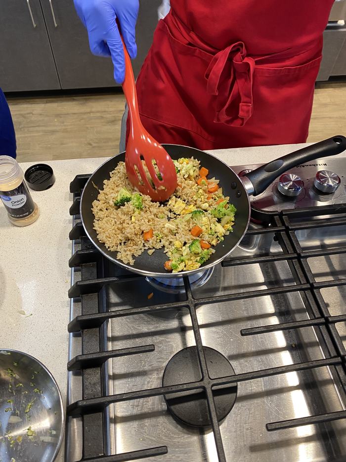 Students cooking stir fry on a stove top