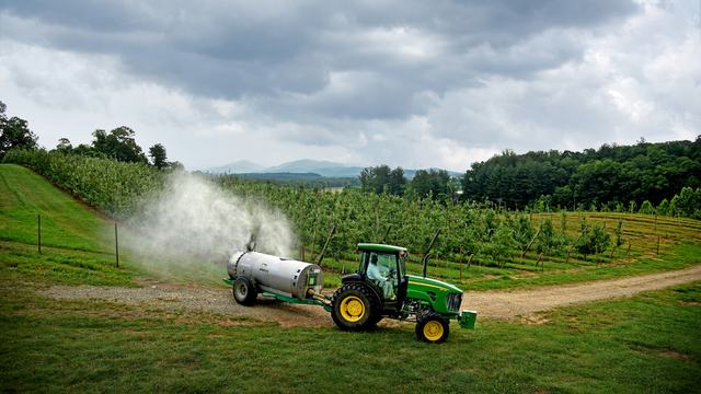 Johnny Barnett sprays apple trees at Mountain Horticultural Research and Extension Center in Henderson County.