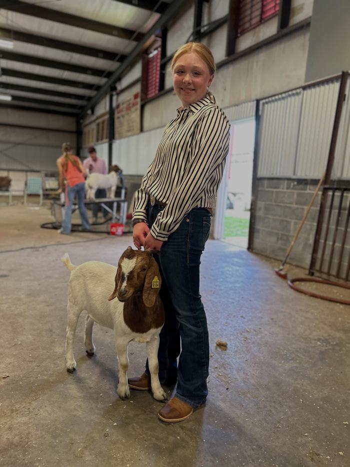 4-Her poses with her Boer goat before her class at the livestock show and sale