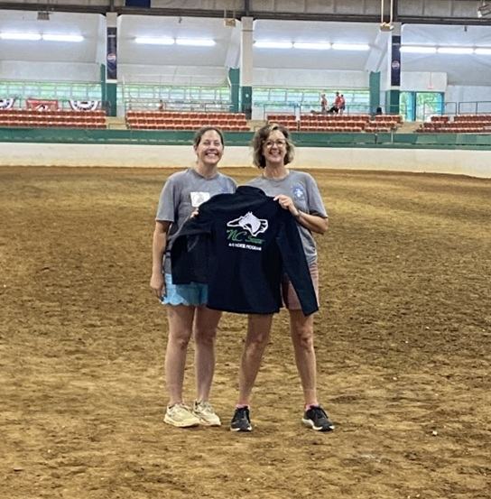 Cameron Lowe poses with her award jacket alongside Alaina Cross in the main arena of the Hunt Horse Complex.