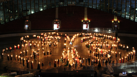 Hundreds of 4-H'ers hold candles to form the shape of the 4-H emblem, as part of the candlelighting ceremony of 4-H Congress.