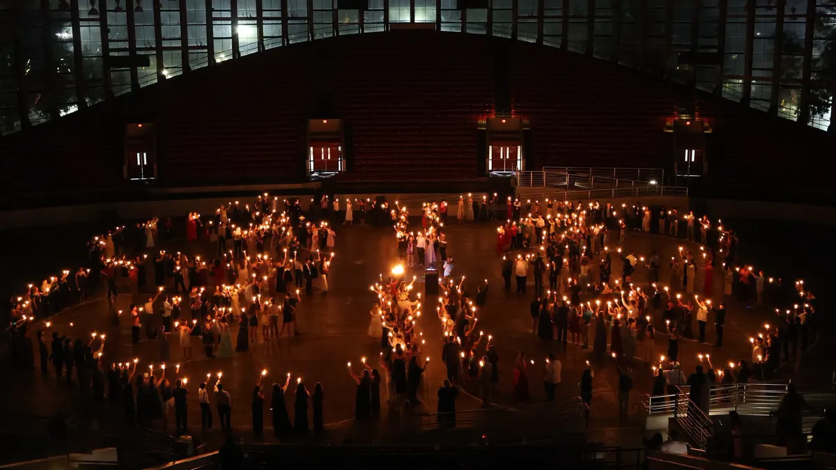 Hundreds of 4-H'ers hold candles to form the shape of the 4-H emblem, as part of the candlelighting ceremony of 2026 4-H Congress.