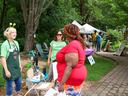 a woman talking to two women at an event in a garden