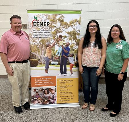 Kayley with partners standing in front of EFNEP banner