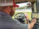 A farmer in a tractor cab using a computer screen