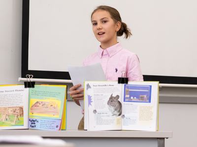 4-H member gives a presentation about guinea pigs and chinchillas using display boards, printed visuals, and presentation materials during Southeast District Activity Day.