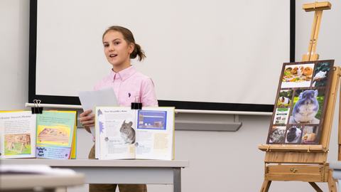 4-H member gives a presentation about guinea pigs and chinchillas using display boards, printed visuals, and presentation materials during Southeast District Activity Day.