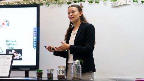 4-H member presents about energy and metabolism using a digital display and demonstration materials during North Central District Activity Day.