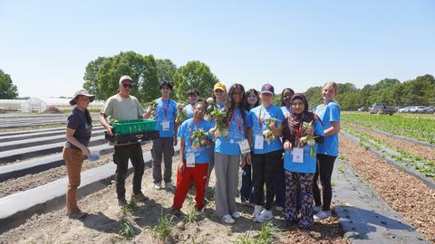 North Carolina Youth Institute students at a farm holding their harvest