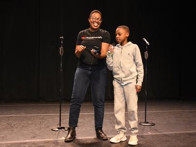 Christy Byrd and a child with a microphone on a stage
