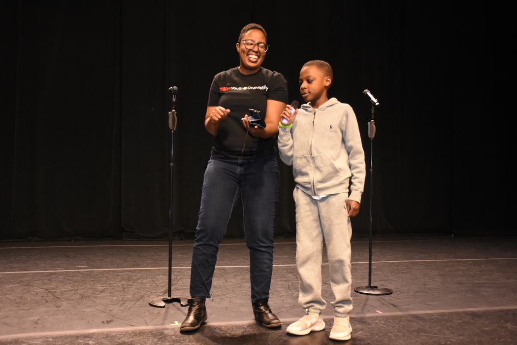 Christy Byrd and a child with a microphone on a stage