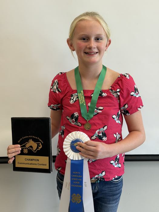 Dakota Kovacs 8-10 Public Speaking Winner with her first place ribbon, medal and padfolio.