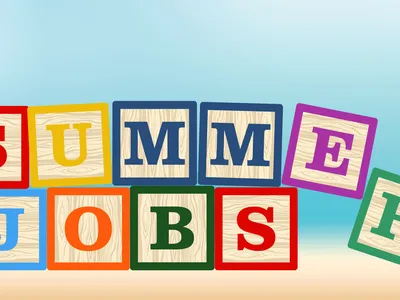Wooden blocks spelling Summer Jobs with a beach background