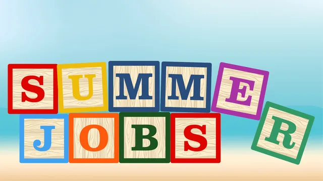 Wooden blocks spelling Summer Jobs with a beach background