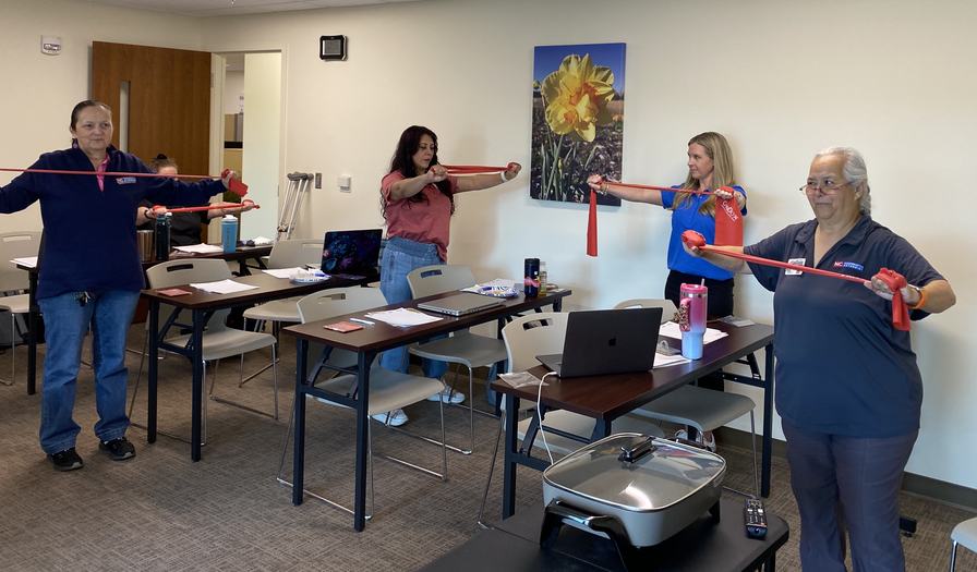 Dinorah leading group physical activity with stretch bands