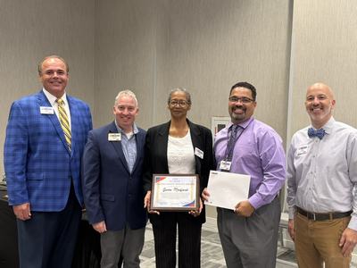 Gwen Medford posing with her distinguished service award plaque with Extension administrators from NC State Extension and NC A&T State Extension