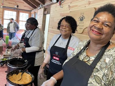 Four women who volunteer with NC State Extension serve food