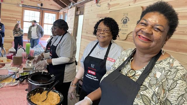 Four women who volunteer with NC State Extension serve food