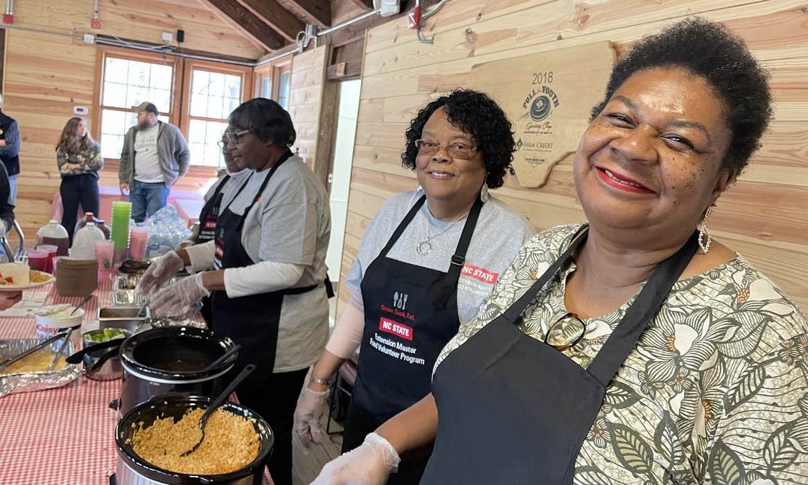 Four women who volunteer with NC State Extension serve food