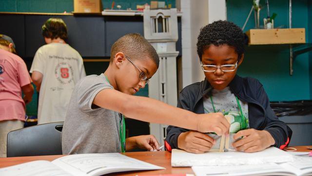 Two young 4-Hers working on a STEM project at a table