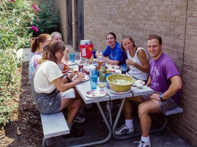 People sitting at picnic table with food