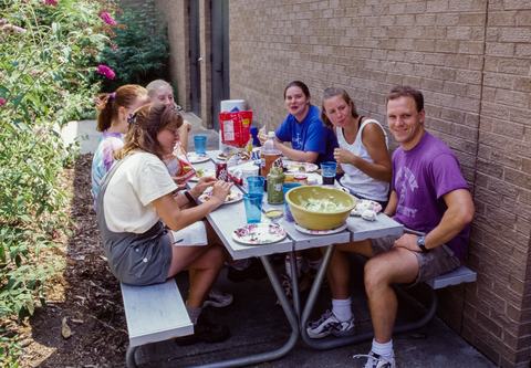 People sitting at picnic table with food