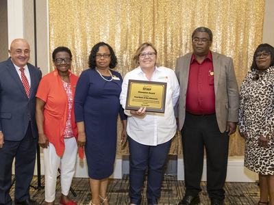 Willie Mae and team holding an award