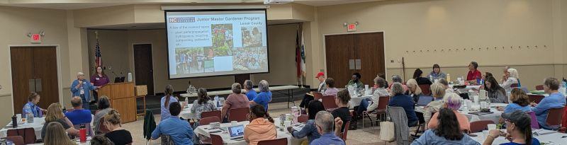 A Master Gardener volunteer presents to a room full of participants.