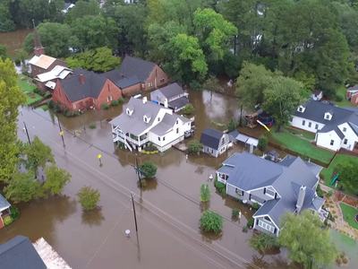 Aerial view of brown floodwater covering Queen Street and surrounding homes and St. Thomas Episcopal Church in Windsor NC after Hurricane Matthew.