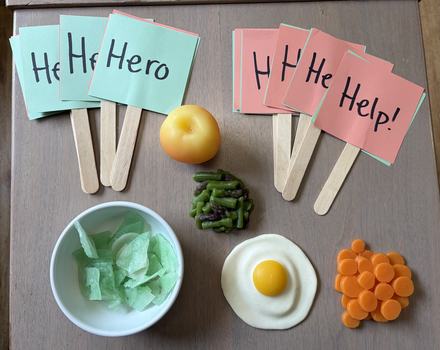 model foods and signs reading 'hero' or 'help'