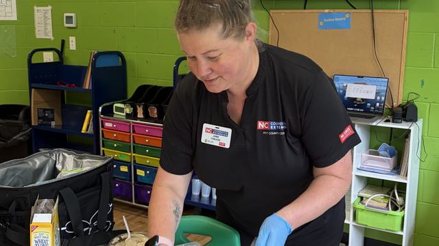 Jamie preparing a snack for youth in a classroom