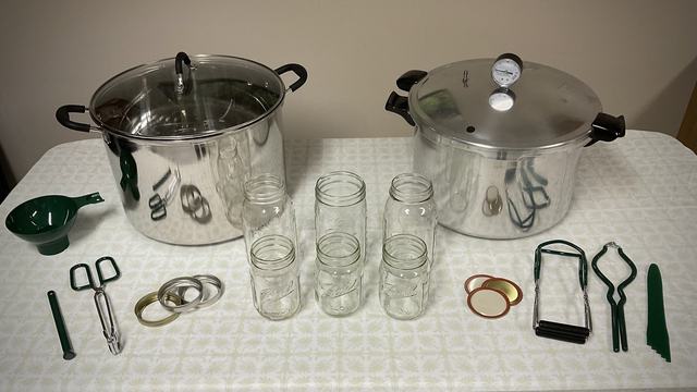dial gauge canner and weighted canner on stove tops with canning jars and other canning equipment