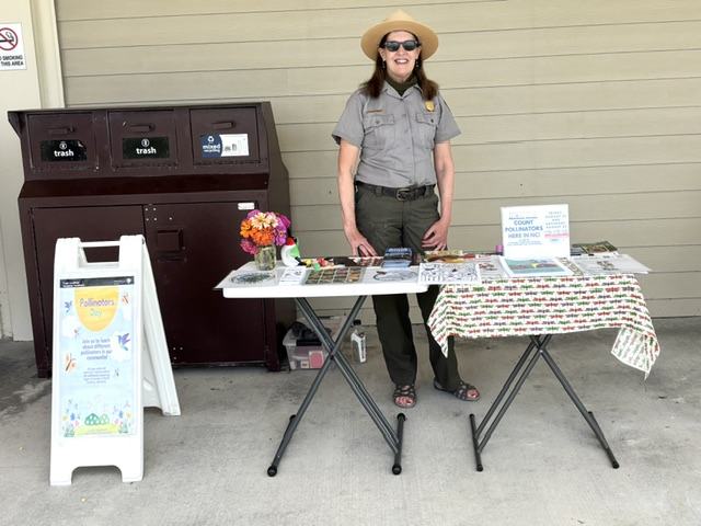 park ranger stand behind table