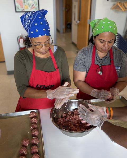 staff wearing aprons and rolling meatballs