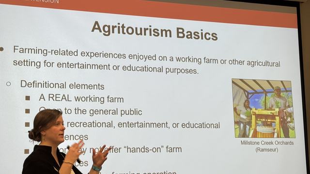 Woman stands in front of slide explaining Agritourism Basics.