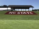 NC State logo painted on a grassy hill at the Lake Wheeler Turfgrass Field Lab in Raleigh, NC.